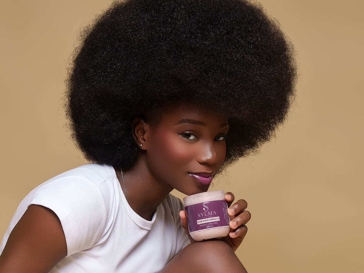 Modèle aux cheveux afro avec le masque capillaire Sylma