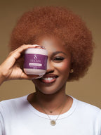 Modèle souriante tenant le masque capillaire Sylma devant son visage
