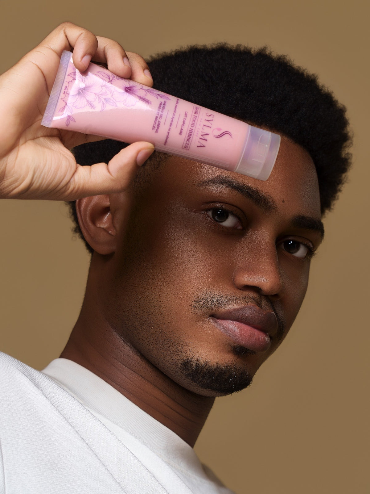 Modèle aux cheveux naturels présentant le lait capillaire Hair Food Hibiscus de SYLMA