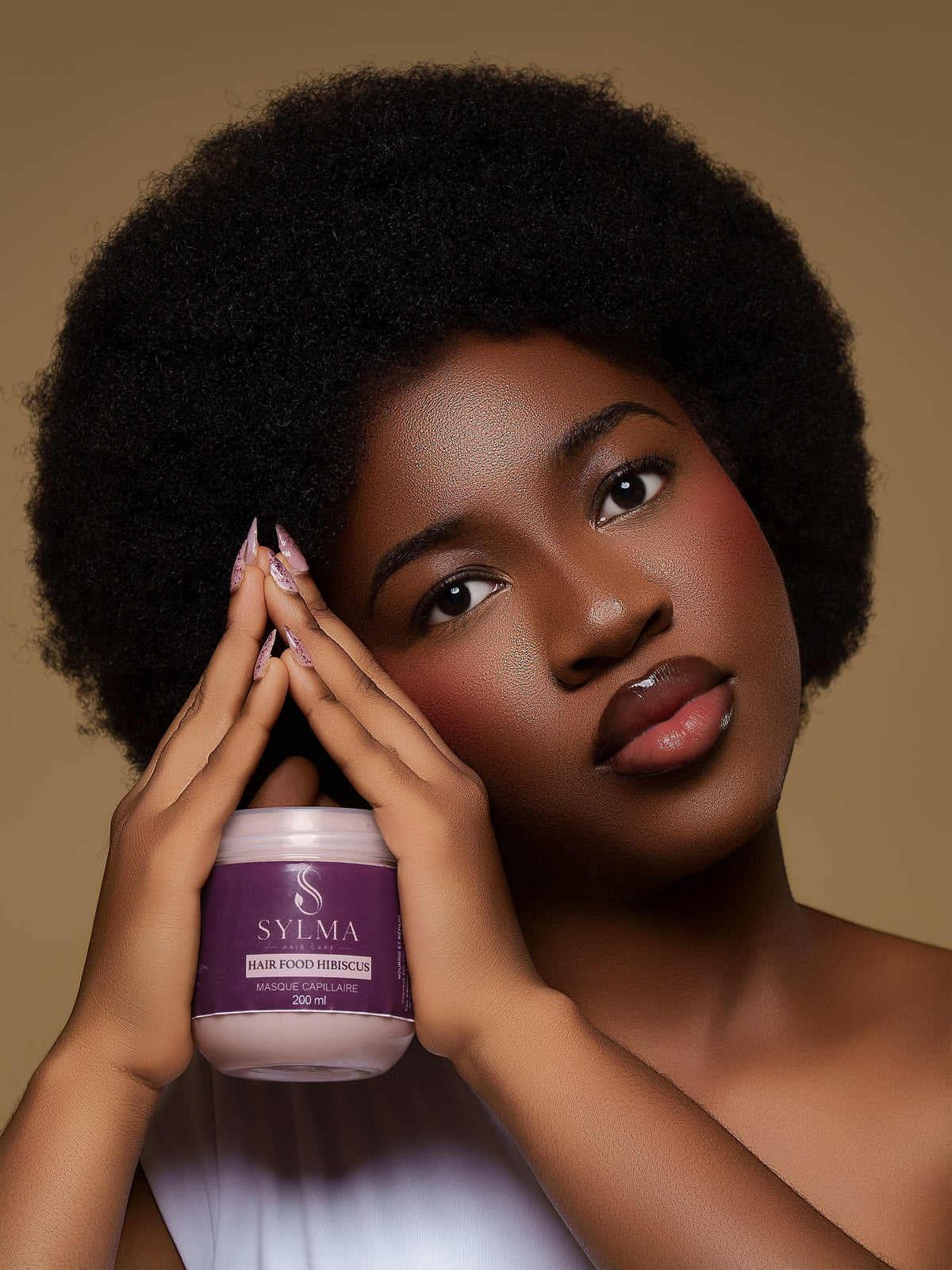 Modèle aux cheveux naturels présentant le masque capillaire Hair Food Hibiscus de SYLMA